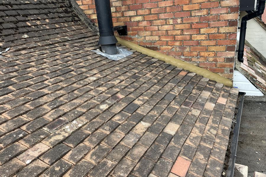 A re-covered roof with neatly laid clay tiles and new lead flashing